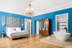 a blue bedroom with a tub and a bed at Água Hotels Lagos Bay in Lagos