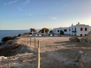 a house on a cliff next to the ocean at My Way Kavos Villa in Agia Marina Aegina