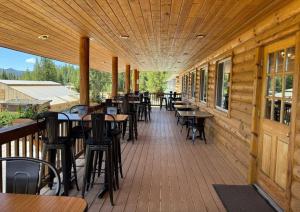 a deck with tables and chairs on a restaurant at Lava Mountain Lodge in Dubois