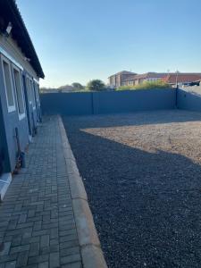 a brick sidewalk next to a fence next to a building at Black Rose Guesthouse Northam in Northam