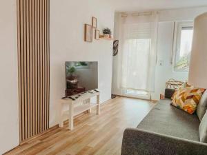 a living room with a couch and a flat screen tv at Ferienhaus "Schmale Gisela" bis zu 6 Personen mit Garten und Parkplätzen in Seligenstadt
