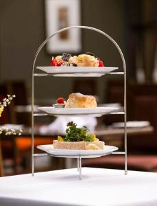a shelf with three plates of food on a table at Alona Hotel in Motherwell +13 photos