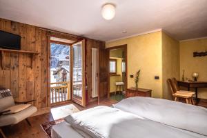 a bedroom with a large bed and a balcony at Anderbätt - Camera e Cucina in Gressoney-la-Trinité