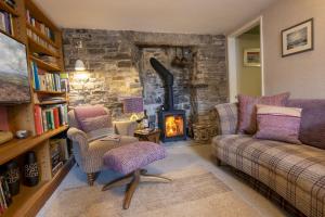 a living room with a couch and a fireplace at Bridge Cottage in Hawes