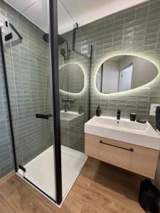 a bathroom with a sink and a mirror at La Tour Somma in Valras-Plage