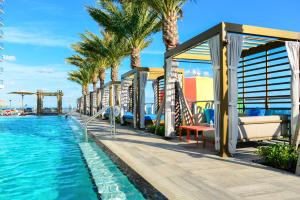 a resort with a pool and palm trees at Hollywood Beach Luxury & Ocean Views in Hollywood