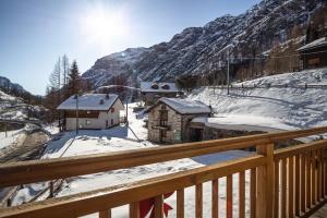 a view from a balcony of a village in the snow at Anderbätt - Camera e Cucina in Gressoney-la-Trinité