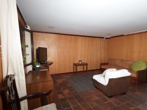 a living room with a couch and a tv at Apartamentos Otorongo in Cuenca