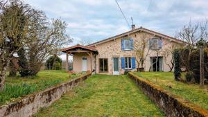 a stone house with a yard in front of it at Chez mamie couture in Bussière-Boffy