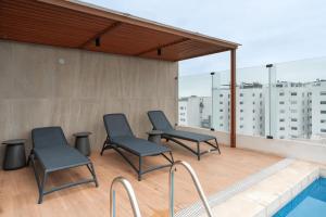 a patio with two chairs and a swimming pool at Ejército City Lofts & Apartments by Geko in Lima