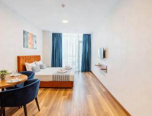 a hotel room with a bed and a table and chairs at Apartments in Navi in Gonio +4 photos