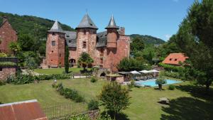 an old castle with a swimming pool in front of it at Château de Vassinhac chambres d'hôtes Collonges la rouge in Collonges