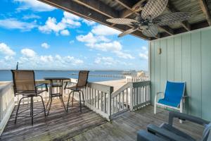 a porch with chairs and a table on the beach at Boardwalk Unit E4 in Pensacola Beach