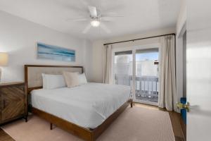 a bedroom with a bed and a large window at Boardwalk Unit E4 in Pensacola Beach