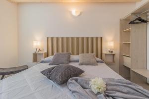 a bedroom with a large white bed with two pillows at Ca Magnolia Appartamento 3 in Lierna