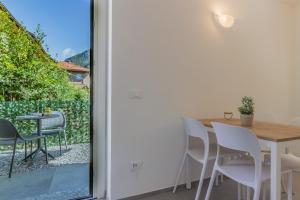 a dining room with a table and chairs next to a sliding glass door at Ca Magnolia Appartamento 2 in Lierna