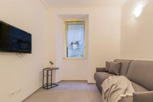 a living room with a couch and a tv at Ca Magnolia Appartamento 2 in Lierna