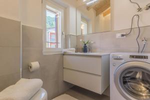 a bathroom with a washing machine and a sink at Ca Magnolia Appartamento 4 in Lierna