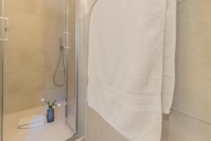 a bathroom with a shower with a white towel at Ca Magnolia Appartamento 4 in Lierna +20 photos