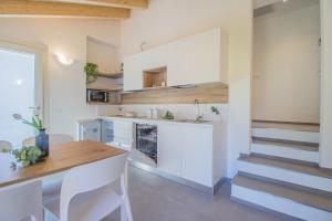 a kitchen with white cabinets and a wooden table at Ca Magnolia Appartamento 4 in Lierna