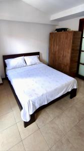a bedroom with a large bed with a wooden cabinet at Tu Estancia en Cali - Valle del Lili in Cali