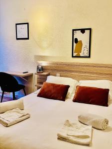 a bedroom with a bed with white sheets and red pillows at La Carpe d'Or in Fontainebleau