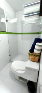 a bathroom with a toilet and a shower with towels at Tu Estancia en Cali - Valle del Lili in Cali +12 photos