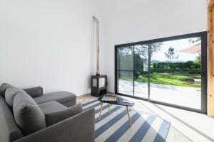 a living room with a couch and a large window at FishTail Guest House in Rabo de Peixe