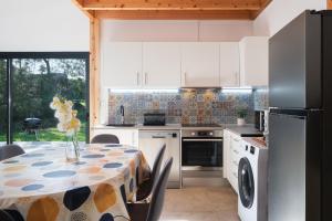 a kitchen with a table and a refrigerator at FishTail Guest House in Rabo de Peixe