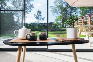 a table with two coffee mugs and a plant on it at FishTail Guest House in Rabo de Peixe