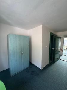ein leerer Raum mit einem blauen Schrank und einer Tür in der Unterkunft Chata na Pile in Sedlice
