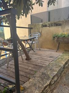a wooden deck with a table and chairs on it at Chambre Le 40 marches in Cucugnan +1 photo
