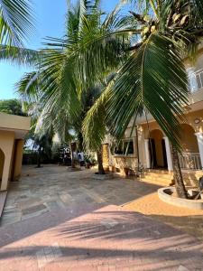 a palm tree in front of a building at Ramaya Auberge Espagnole in Grand-Popo