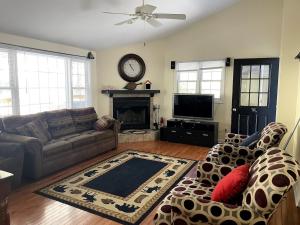 a living room with a couch and a clock on the wall at Mountain home in Newland in Newland