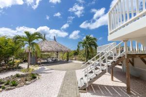 a staircase leading up to a building with a thatch roof at Villa Kas Karibense 38 - Coral Estate in Willibrordus