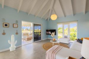 a living room with a white couch and a tv at Villa Kas Karibense 38 - Coral Estate in Willibrordus