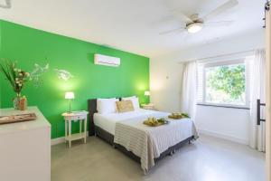 a green bedroom with a bed and a green wall at Villa Kas Karibense 38 - Coral Estate in Willibrordus +17 photos