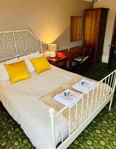 a bedroom with a white bed with yellow pillows at The Lincoln Arms Pub & Rooms in Dorking