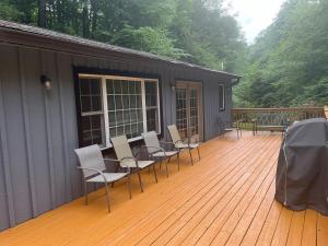 a deck with chairs and tables and a building at Mountain home in Newland in Newland