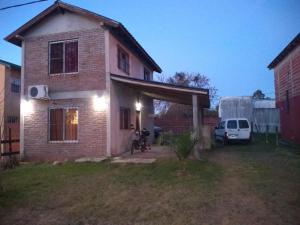 a house with a motorcycle parked in front of it at Casa Ibira pita in Pueblo Liebig