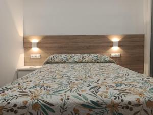 a bedroom with a bed with a floral bedspread at Llano 71 -B- in Archidona