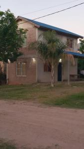 a house with a palm tree in front of it at Casa Ibira pita in Pueblo Liebig