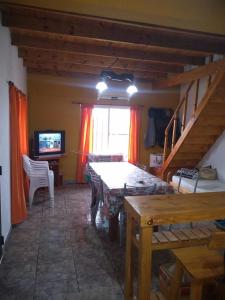 a living room with a table and a couch and a television at Casa Ibira pita in Pueblo Liebig