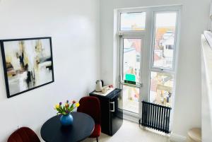 a living room with a table and a window at Reef Lodge in Newquay