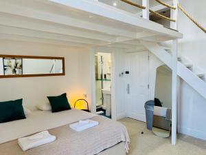 a bedroom with a white bed and a staircase at Reef Lodge in Newquay