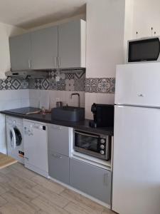 a kitchen with a white refrigerator and a sink at Villa Club T2 complètement rénové à Mar Vivo, plages à pieds, piscine in La Seyne-sur-Mer