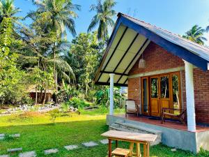 a small house with a picnic table in front of it at Sigiriya Lahiru Homestay in Sigiriya