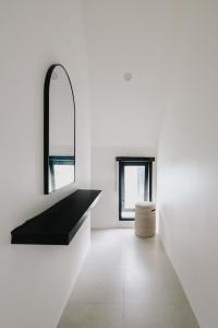 a white room with a black counter and two windows at Paniora Loft Villas in Kuta Lombok +8 photos