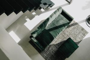 a green couch in a living room with a rug at Paniora Loft Villas in Kuta Lombok