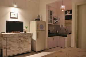 a kitchen with a white refrigerator and a tv at Gypsy Soul Gateaway - Casa Boho in Zirakpur
